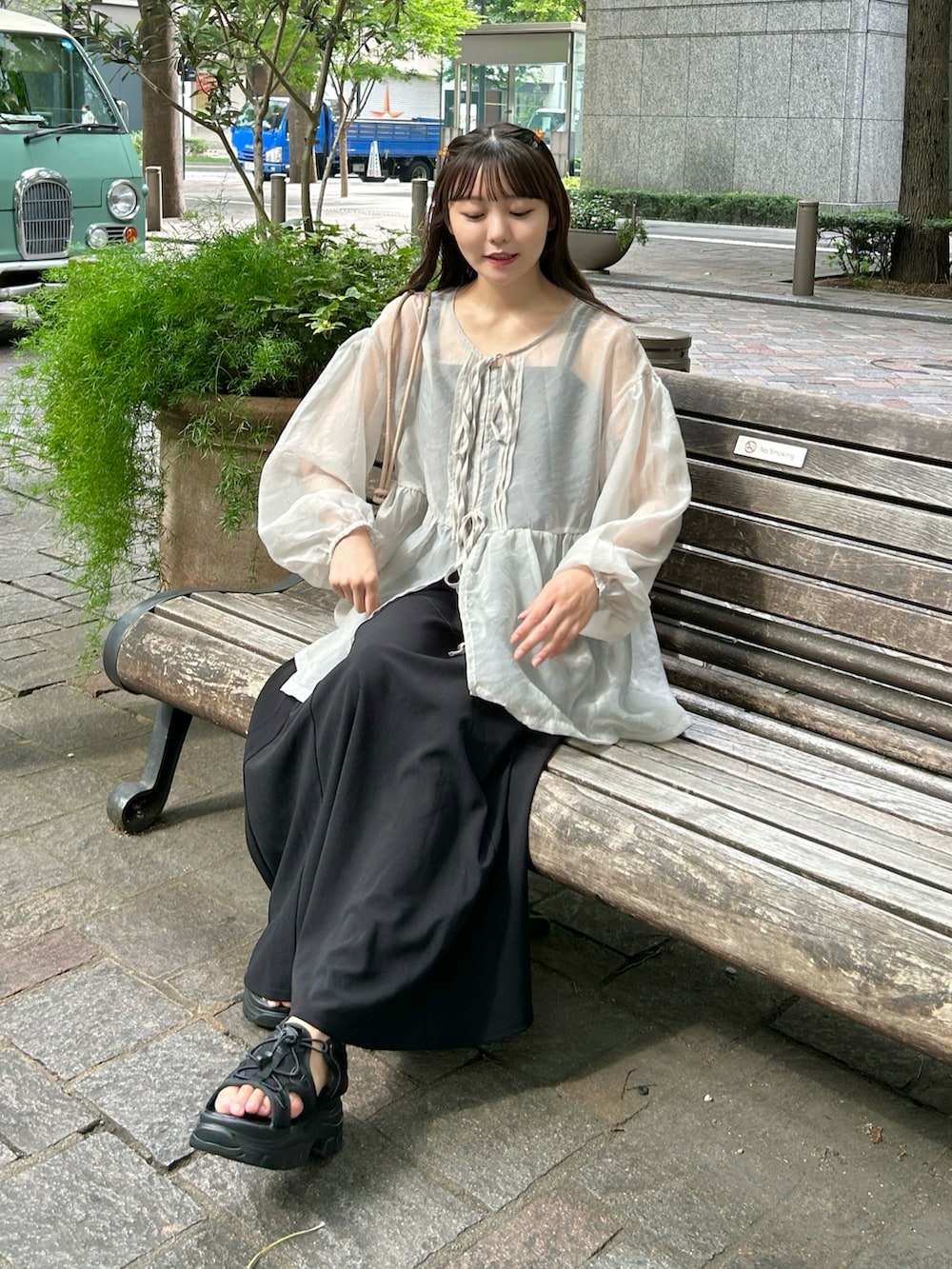 ベージュ系のトップス、ホワイト系のキャミソール、ブラック系のワンピースを着用したレディースの夏コーディネートの5枚目の写真