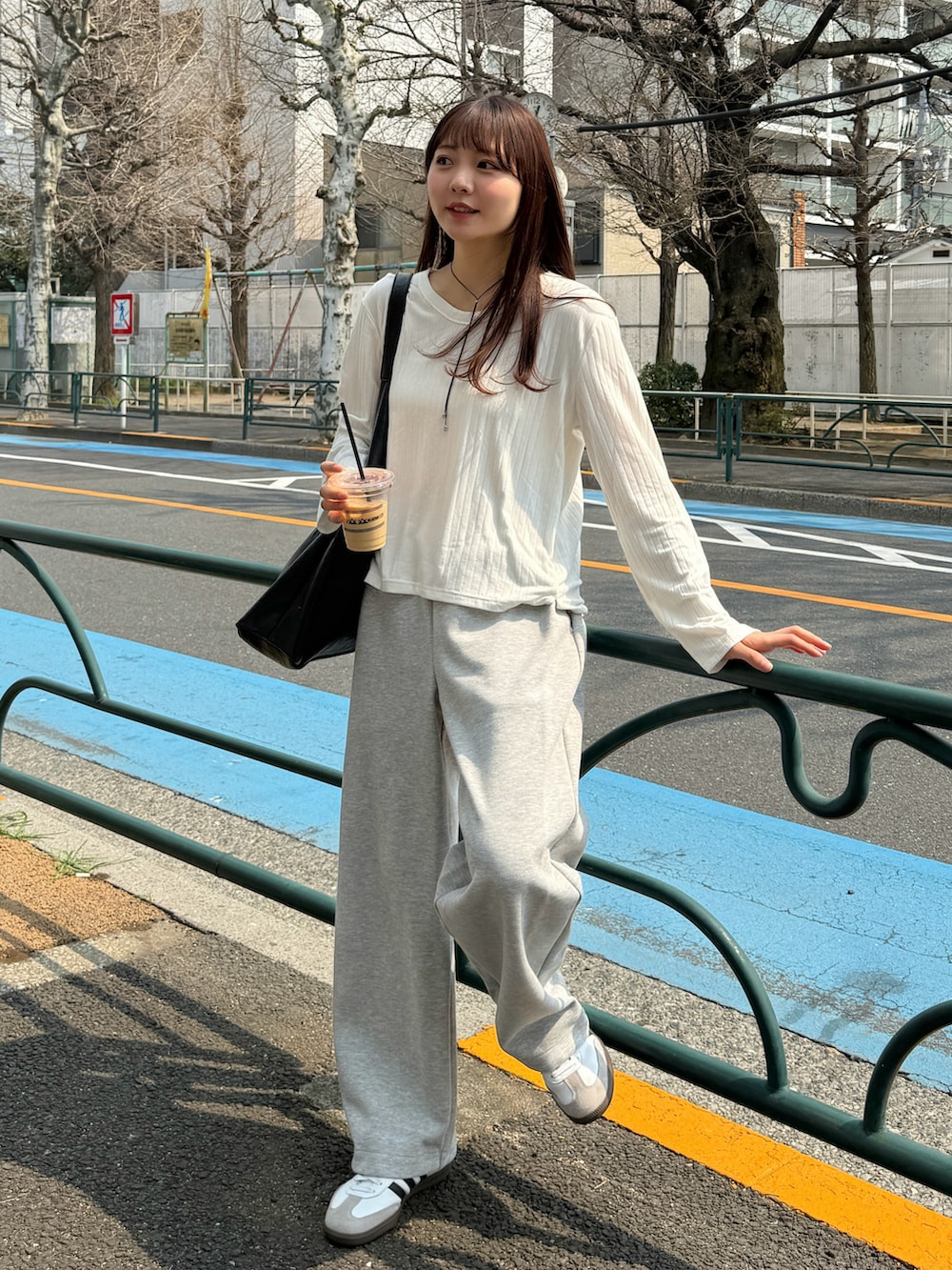 ホワイト系のTシャツ/カットソー、ブラック系のバッグ、グレー系のスウェットパンツを着用したレディースの春コーディネートの5枚目の写真