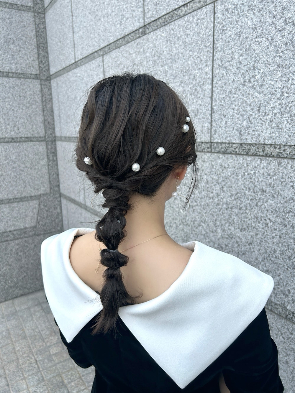 ブラック系のドレス、ホワイト系のハンドバッグ、ブラック系のパンプスを着用したレディースの夏コーディネートの3枚目の写真