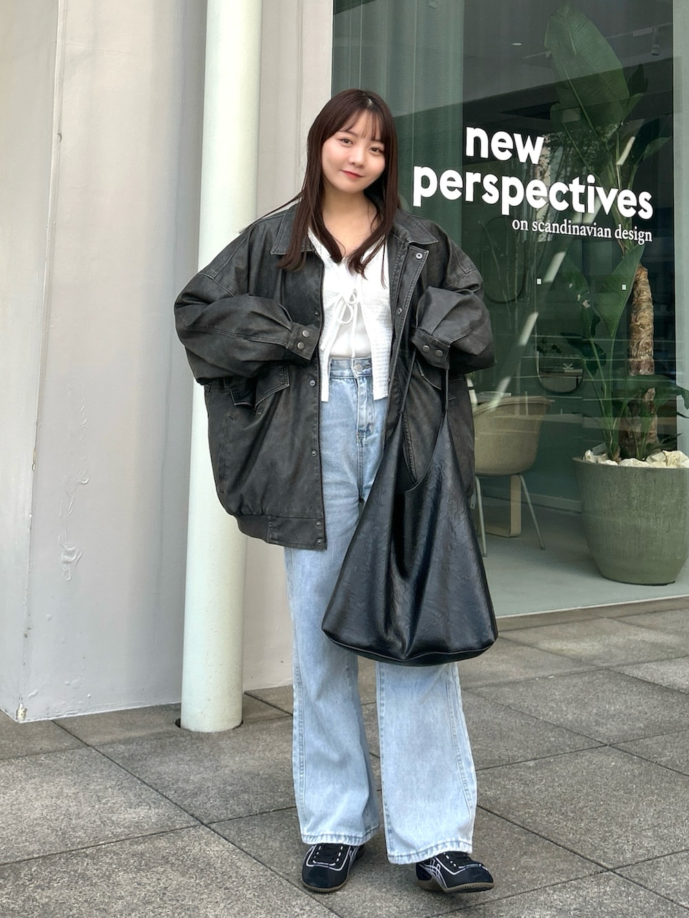 ブルー系のデニムパンツ、ブラック系のバッグ、ホワイト系のカーディガン/ボレロを着用したレディースの冬コーディネートの4枚目の写真