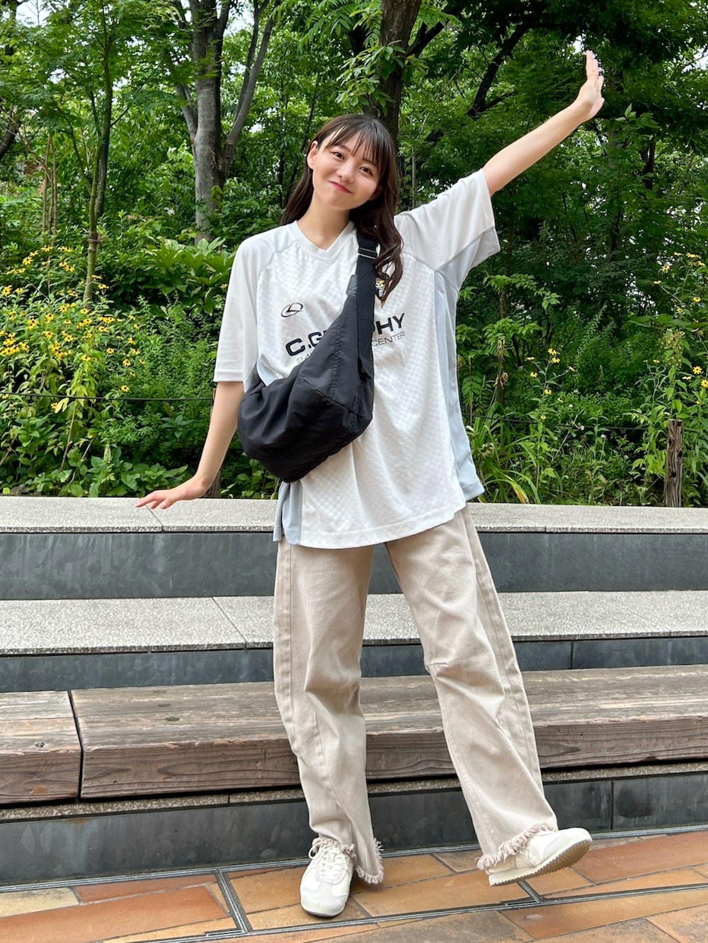 ホワイト系のTシャツ/カットソー、ブラック系のショルダーバッグ、ベージュ系のデニムパンツを着用したレディースの夏コーディネートの2枚目の写真