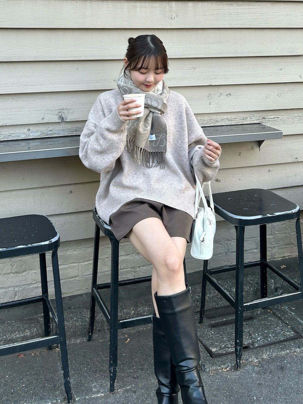 ホワイト系のバッグ、ブラック系のブーツ、ブラウン系のその他パンツを着用したレディースの冬コーディネートの3枚目の写真