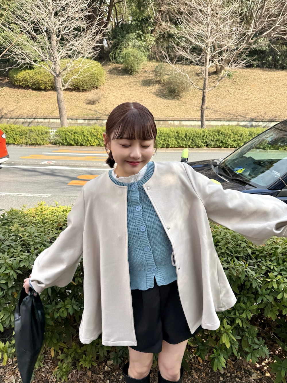 ブルー系のカーディガン/ボレロ、ホワイト系のTシャツ/カットソー、ブラック系のハンドバッグを着用したレディースの冬コーディネートの4枚目の写真