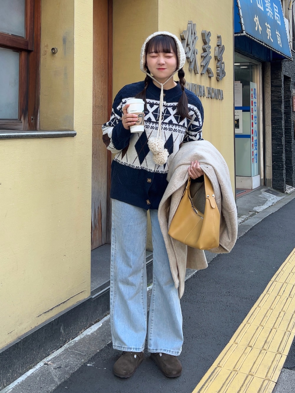 ブルー系のニット/セーター、ブルー系のデニムパンツ、ブラウン系のサンダルを着用したレディースの冬コーディネートの2枚目の写真