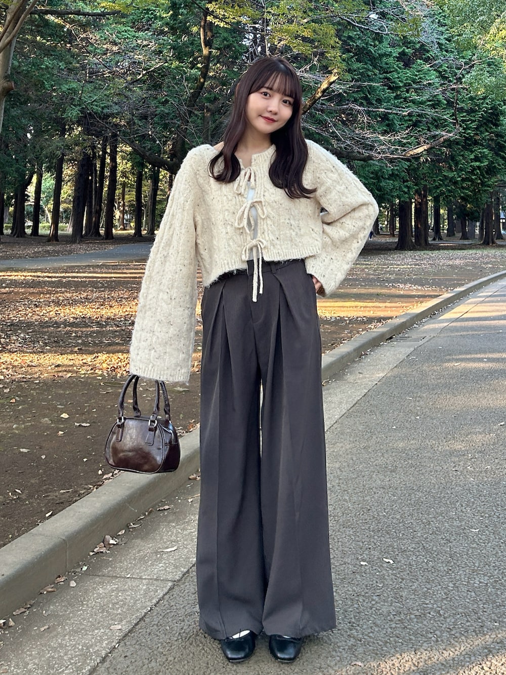 ベージュ系のカーディガン/ボレロ、ホワイト系のキャミソール、ホワイト系のダウンジャケット/コートを着用したレディースの冬コーディネートの2枚目の写真