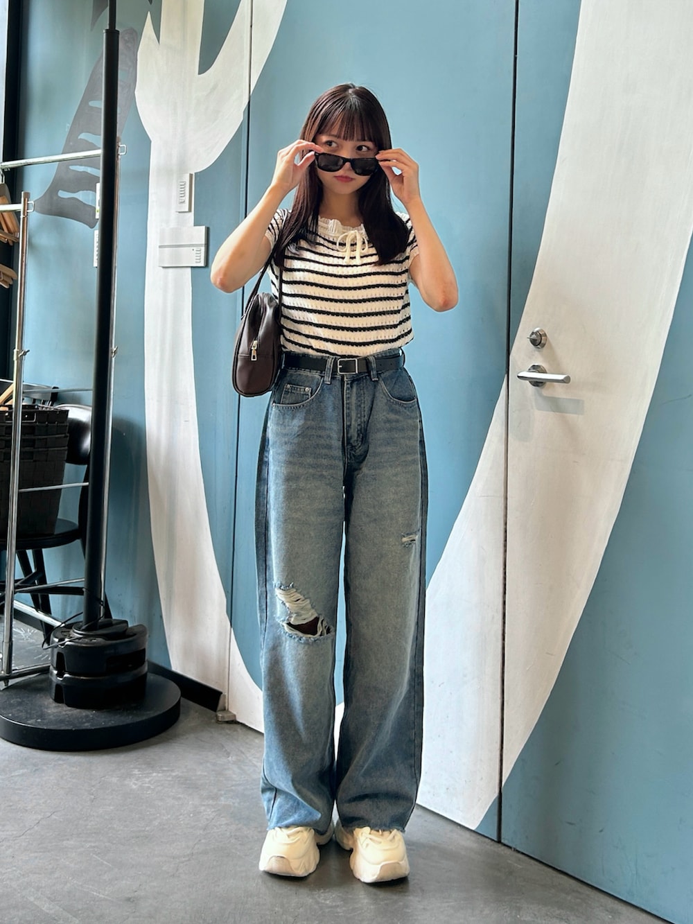 その他のニット/セーター、ブラウン系のバッグ、ブルー系のデニムパンツを着用したレディースの夏コーディネートの2枚目の写真