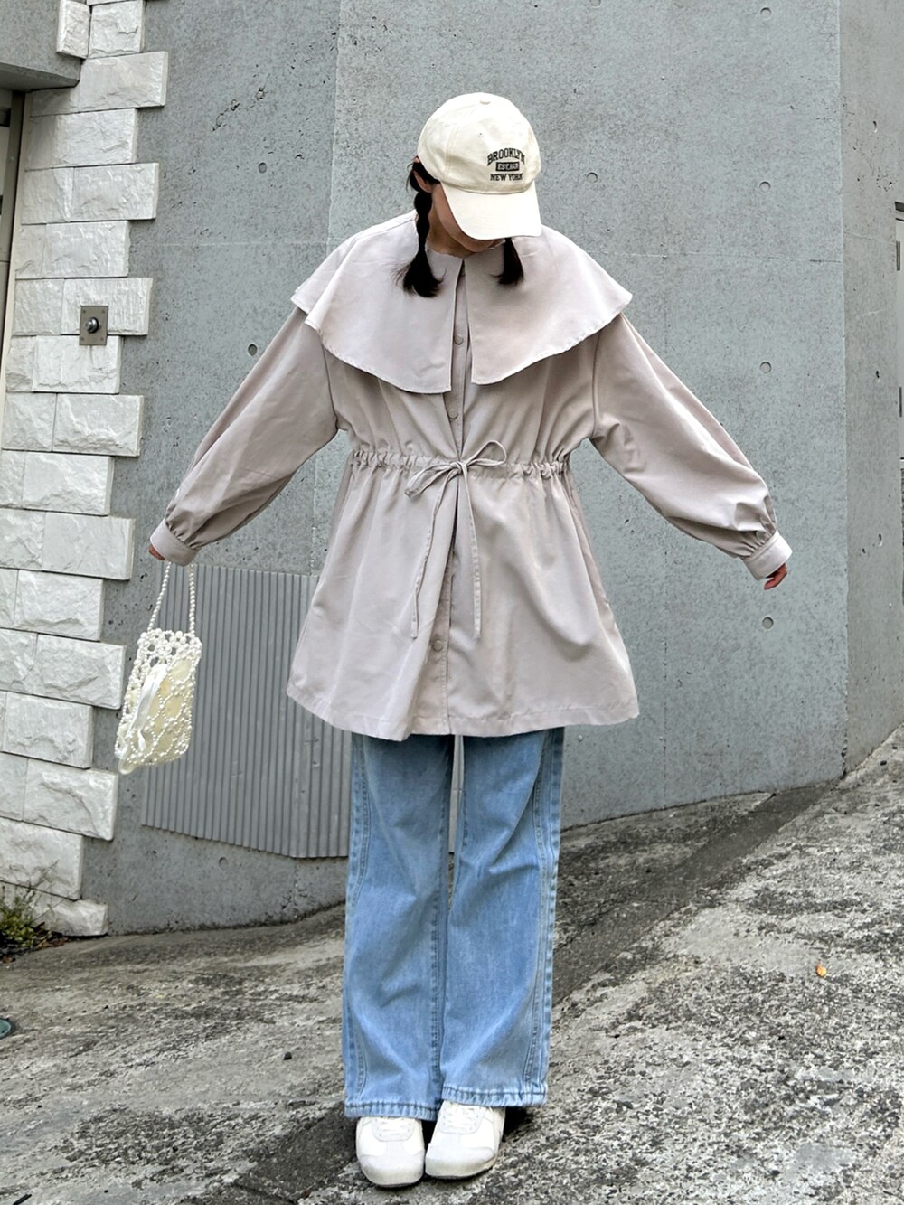 ベージュ系のジャケット/アウター、ブルー系のデニムパンツ、ベージュ系のスニーカーを着用したレディースの春コーディネートの2枚目の写真