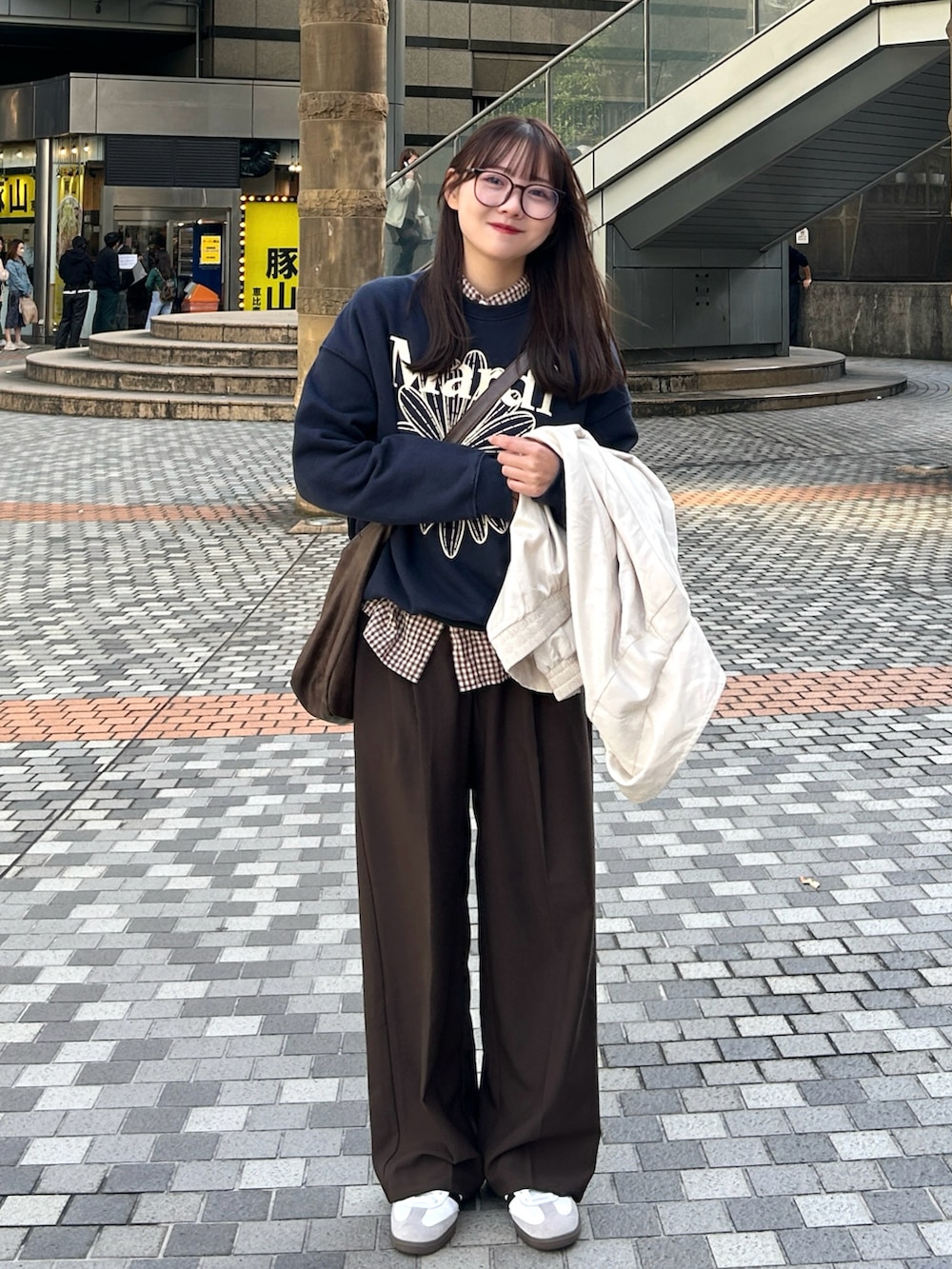 ブルー系のスウェット、ベージュ系のブルゾン、ブラウン系のパンツを着用したレディースの秋コーディネートの5枚目の写真