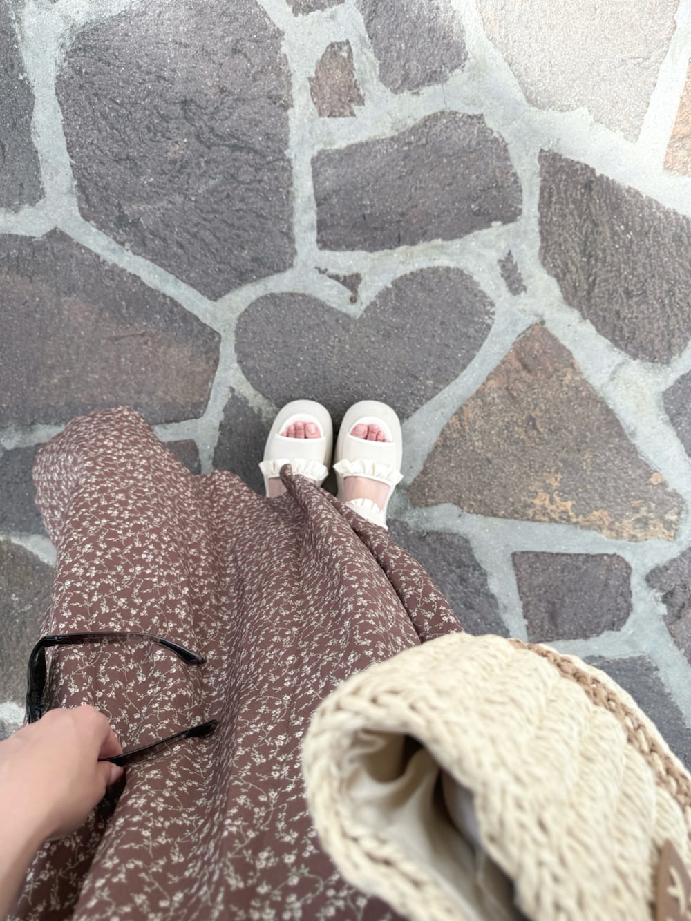 ブラウン系のワンピース、ホワイト系のサンダル、ホワイト系のかごバッグを着用したレディースの夏コーディネートの5枚目の写真