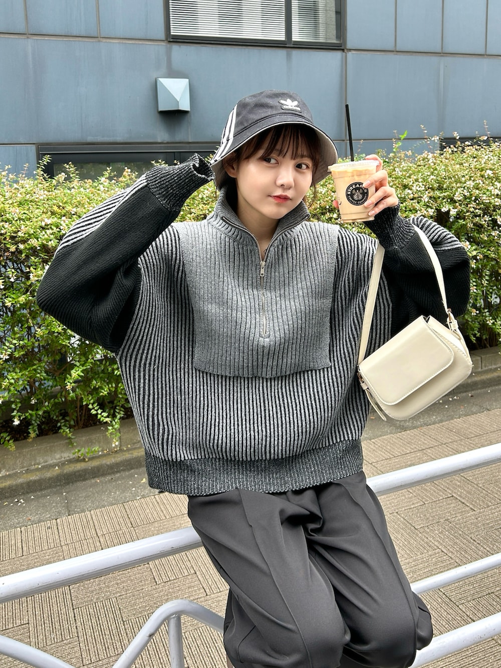 ブラック系のニット/セーター、ブラック系のスラックス、ホワイト系のスニーカーを着用したレディースの秋コーディネートの5枚目の写真