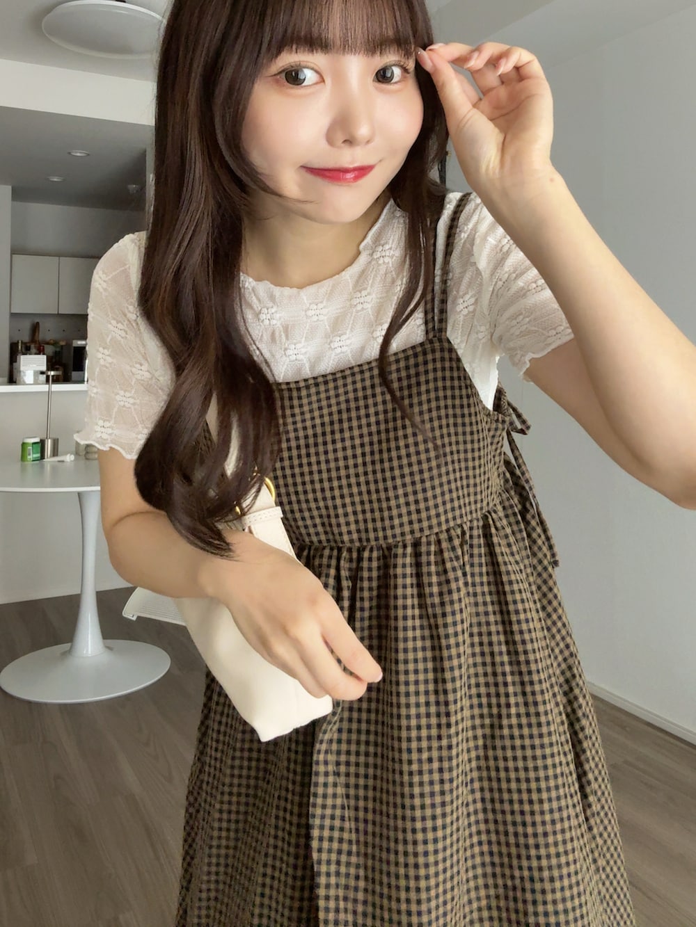 ホワイト系のTシャツ/カットソー、ブラウン系のワンピース、ホワイト系のハンドバッグを着用したレディースの秋コーディネートの3枚目の写真