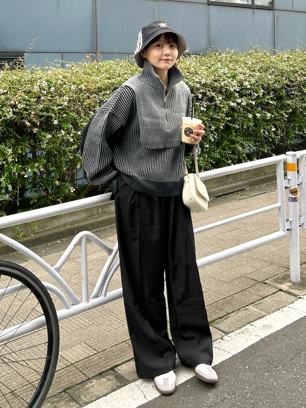 ブラック系のニット/セーター、ブラック系のスラックス、ホワイト系のスニーカーを着用したレディースの秋コーディネートの2枚目の写真