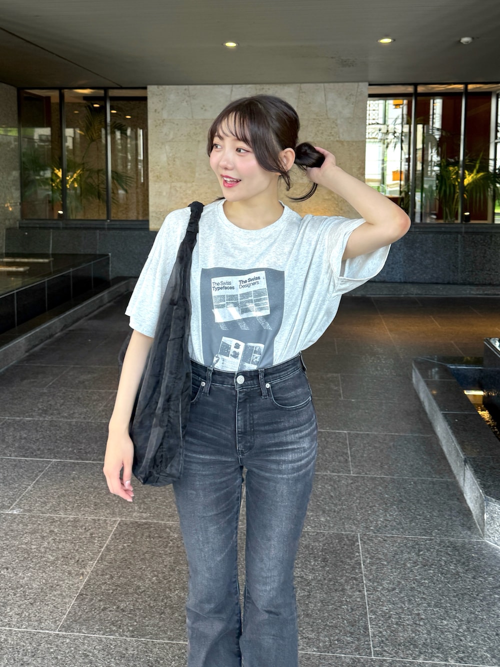 グレー系のTシャツ/カットソー、ブラック系のトートバッグ、ホワイト系のサンダルを着用したレディースの夏コーディネートの3枚目の写真