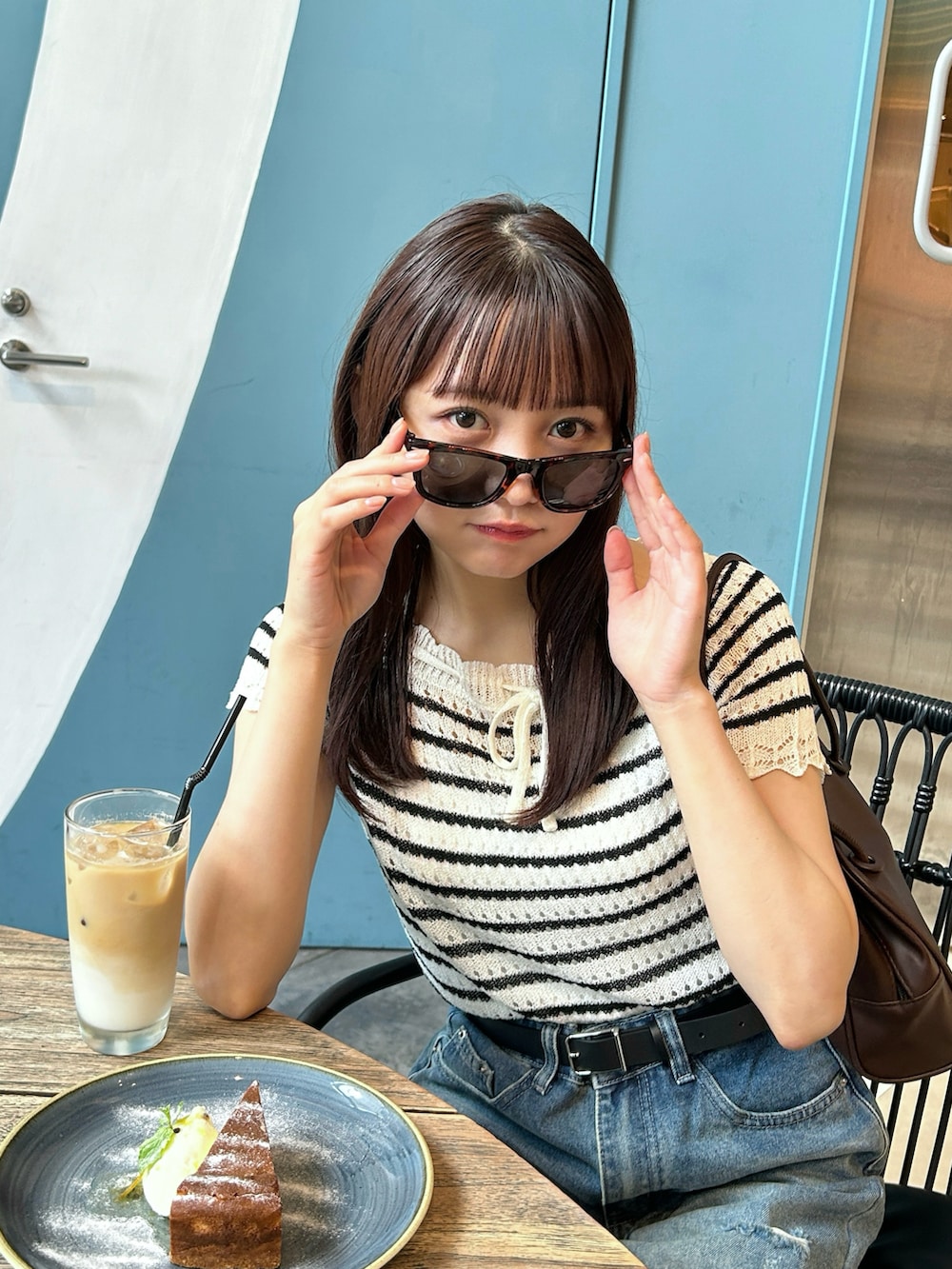 その他のニット/セーター、ブラウン系のバッグ、ブルー系のデニムパンツを着用したレディースの夏コーディネートの4枚目の写真