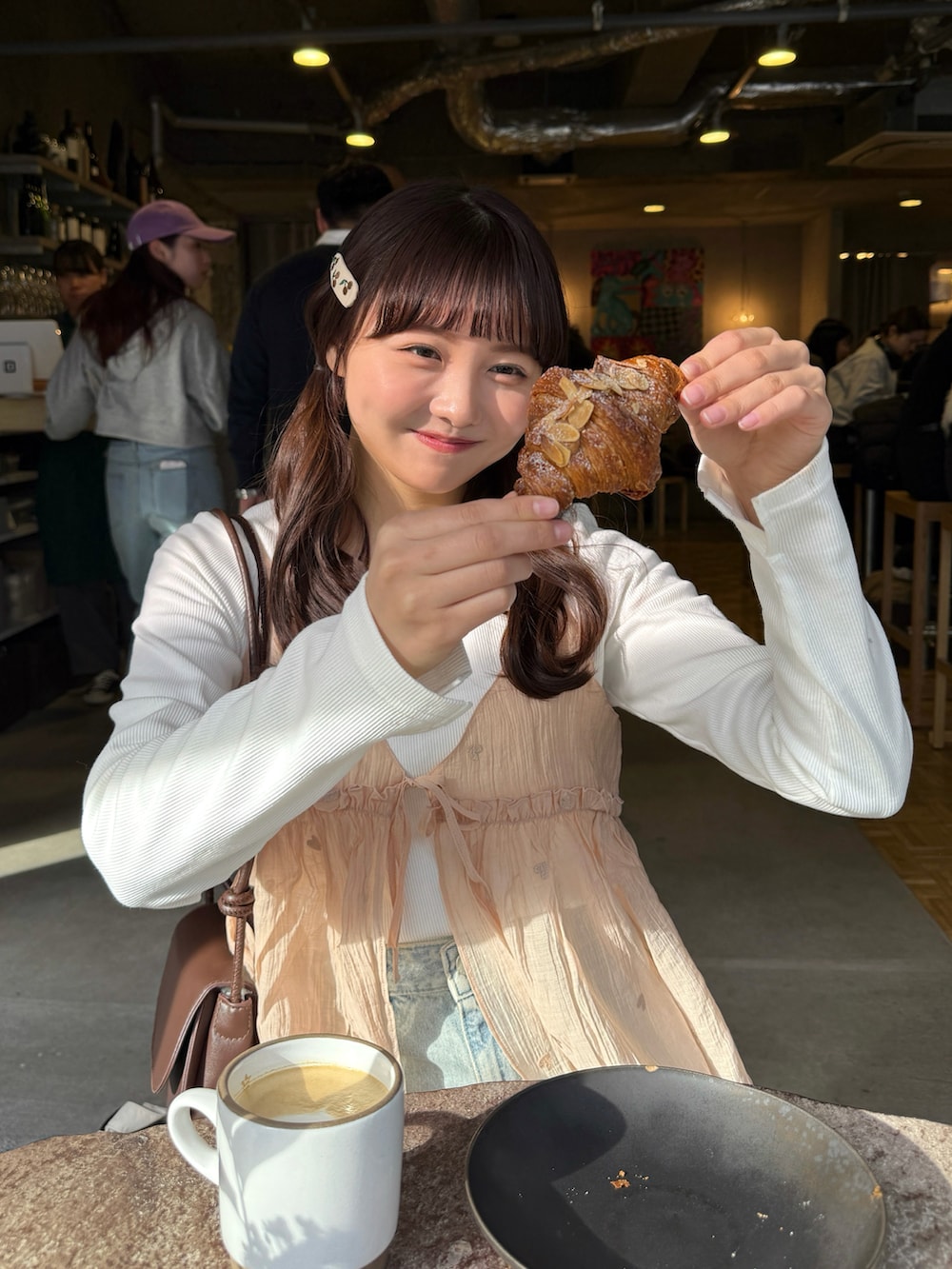 ピンク系のキャミソール、ホワイト系のトップス、ブルー系のデニムパンツを着用したレディースの春コーディネートの5枚目の写真