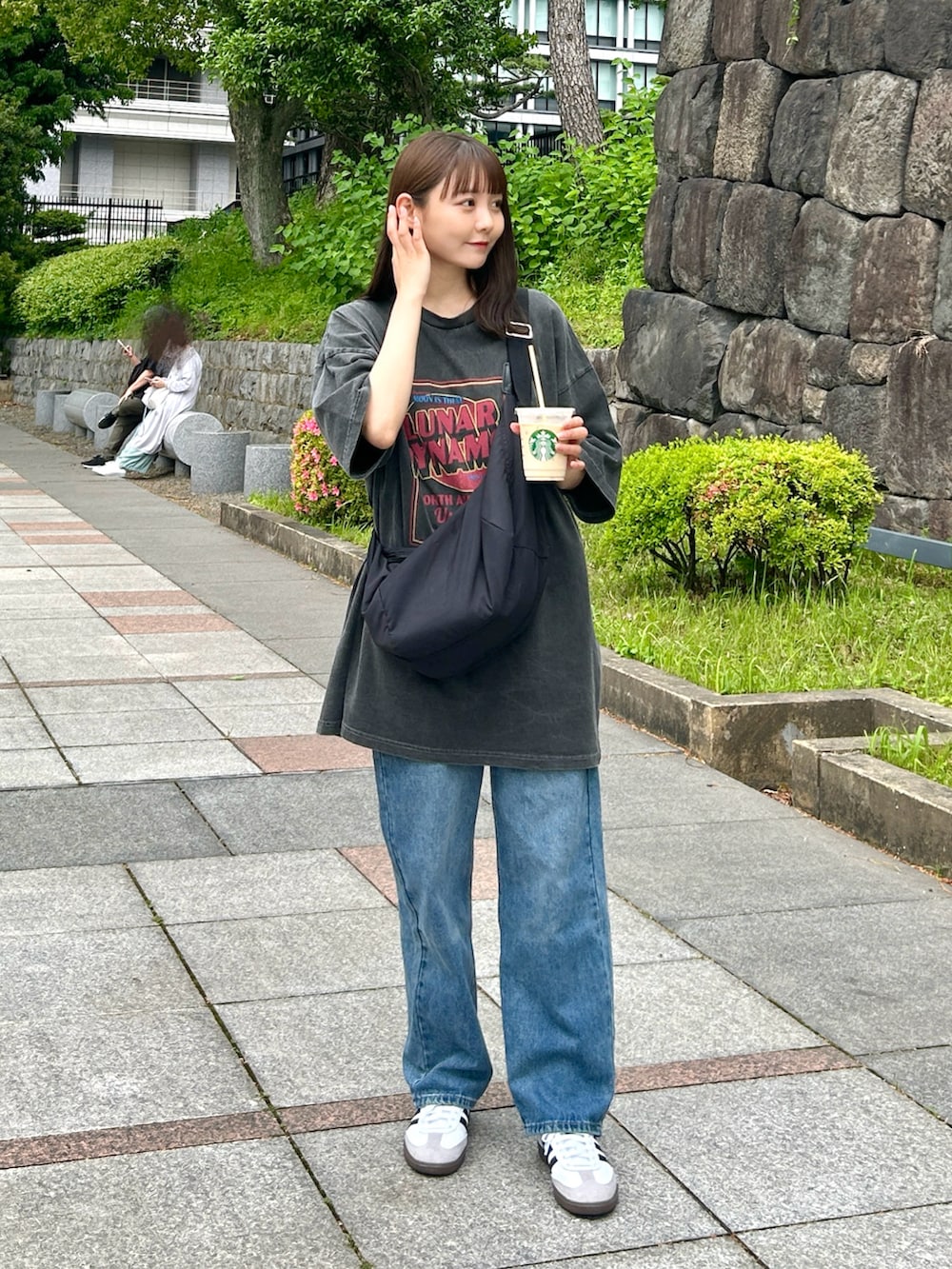 ブラック系のショルダーバッグ、ブルー系のデニムパンツ、ホワイト系のスニーカーを着用したレディースの夏コーディネートの5枚目の写真