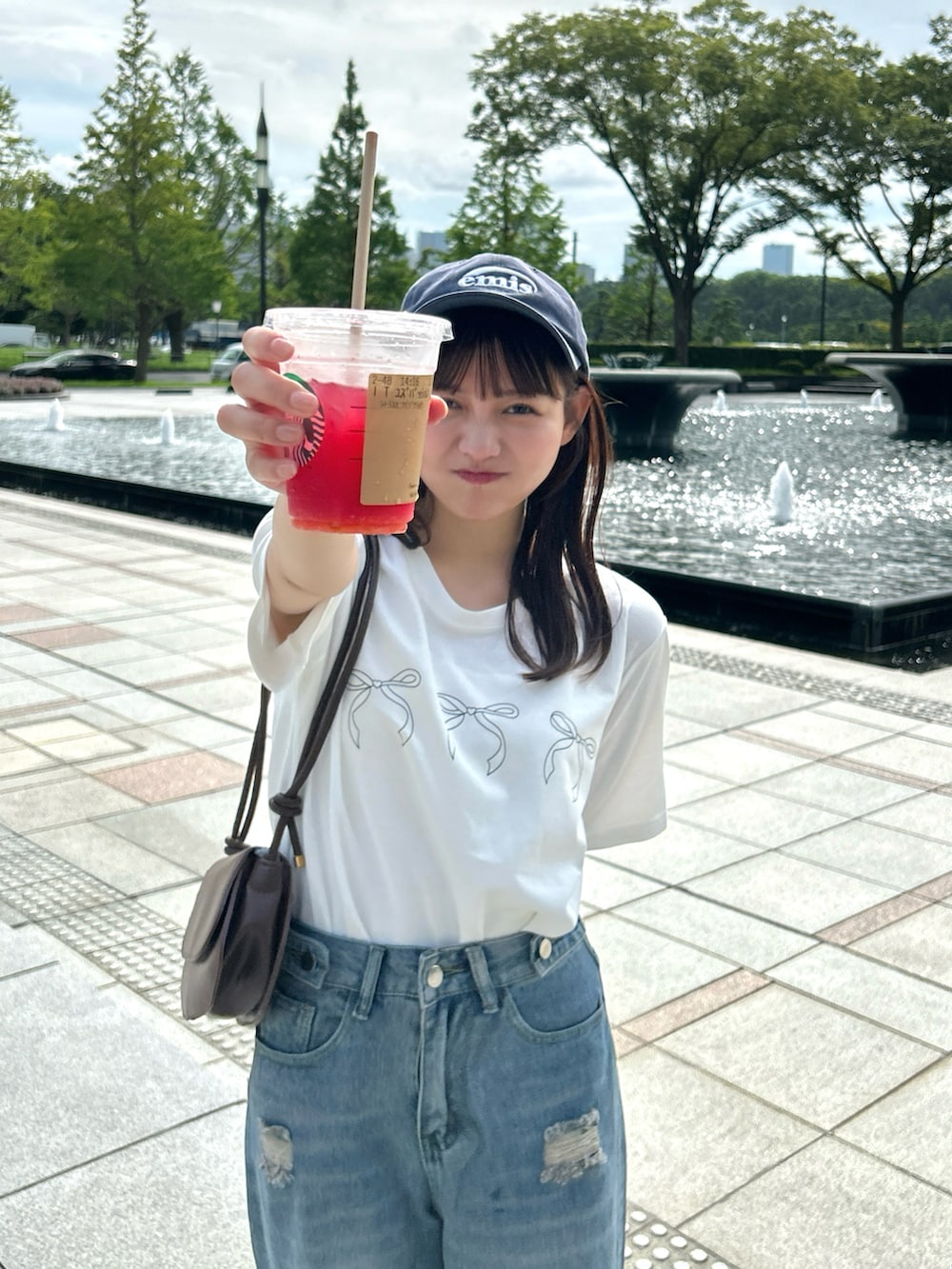 ブルー系のデニムパンツ、ブラウン系のバッグ、ホワイト系のTシャツ/カットソーを着用したレディースの秋コーディネートの3枚目の写真