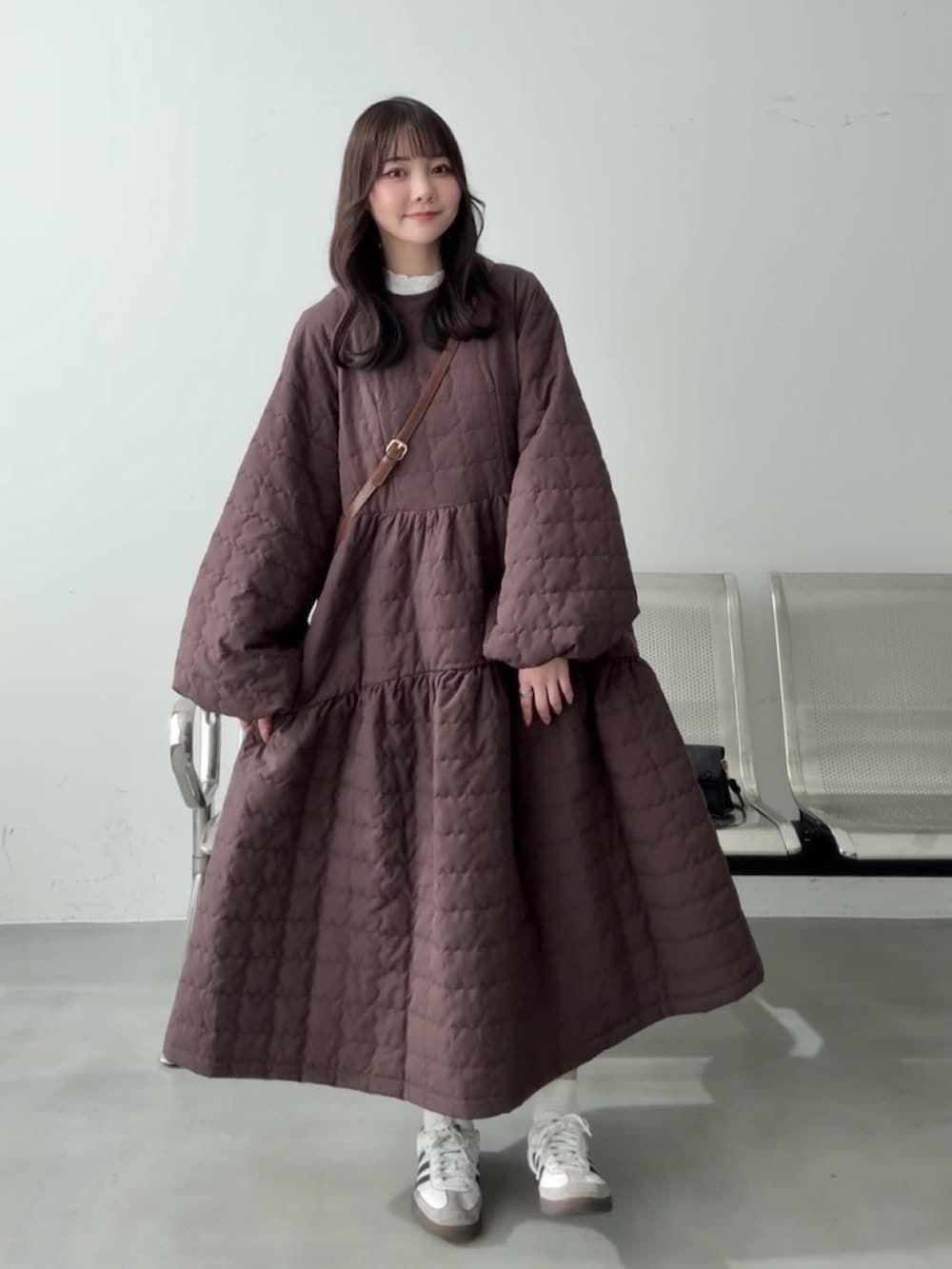 ホワイト系のスニーカー、ブラウン系のその他アウター、イエロー系のショルダーバッグを着用したレディースの冬コーディネートの2枚目の写真