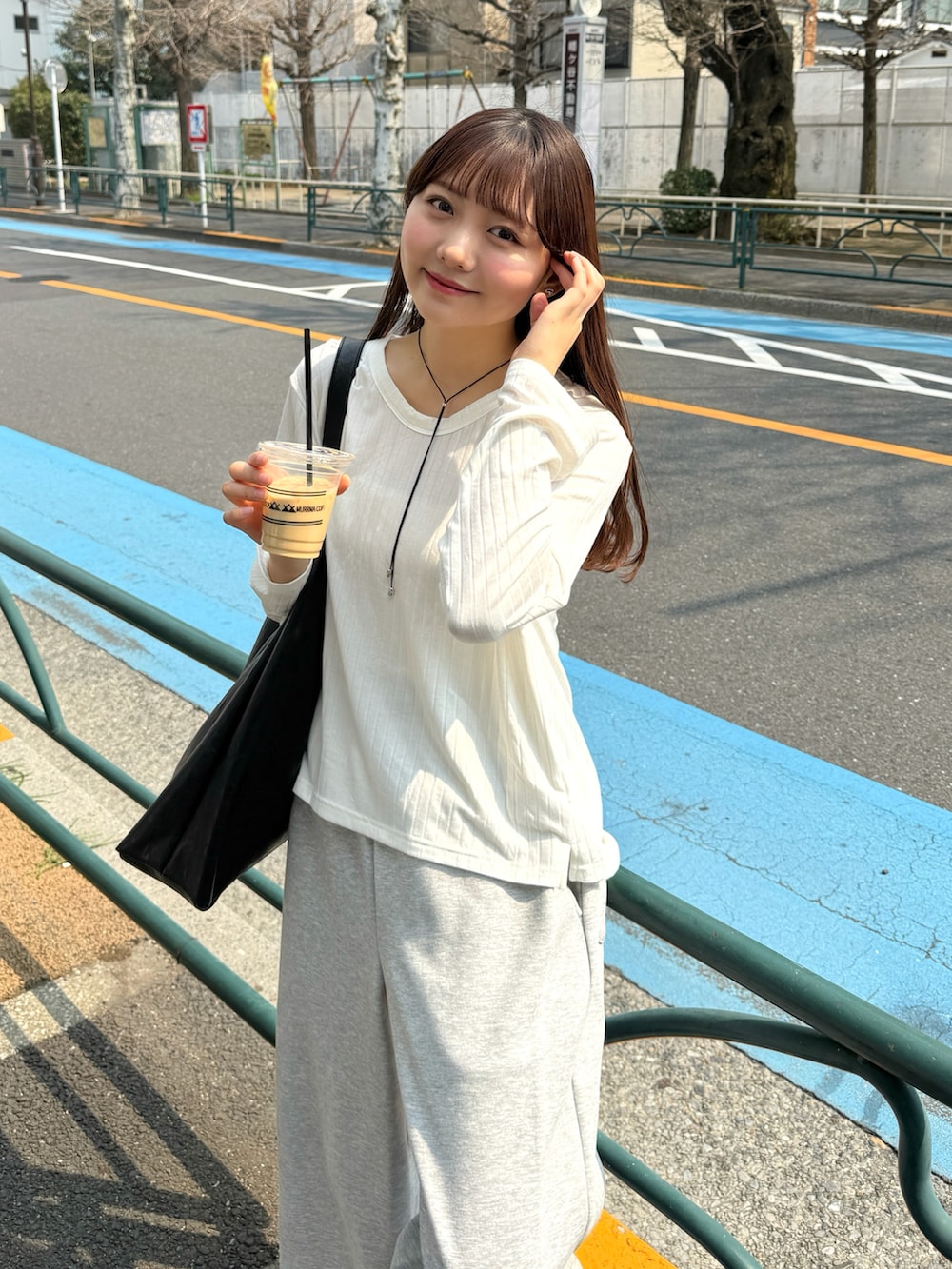 ホワイト系のTシャツ/カットソー、ブラック系のバッグ、グレー系のスウェットパンツを着用したレディースの春コーディネートの3枚目の写真