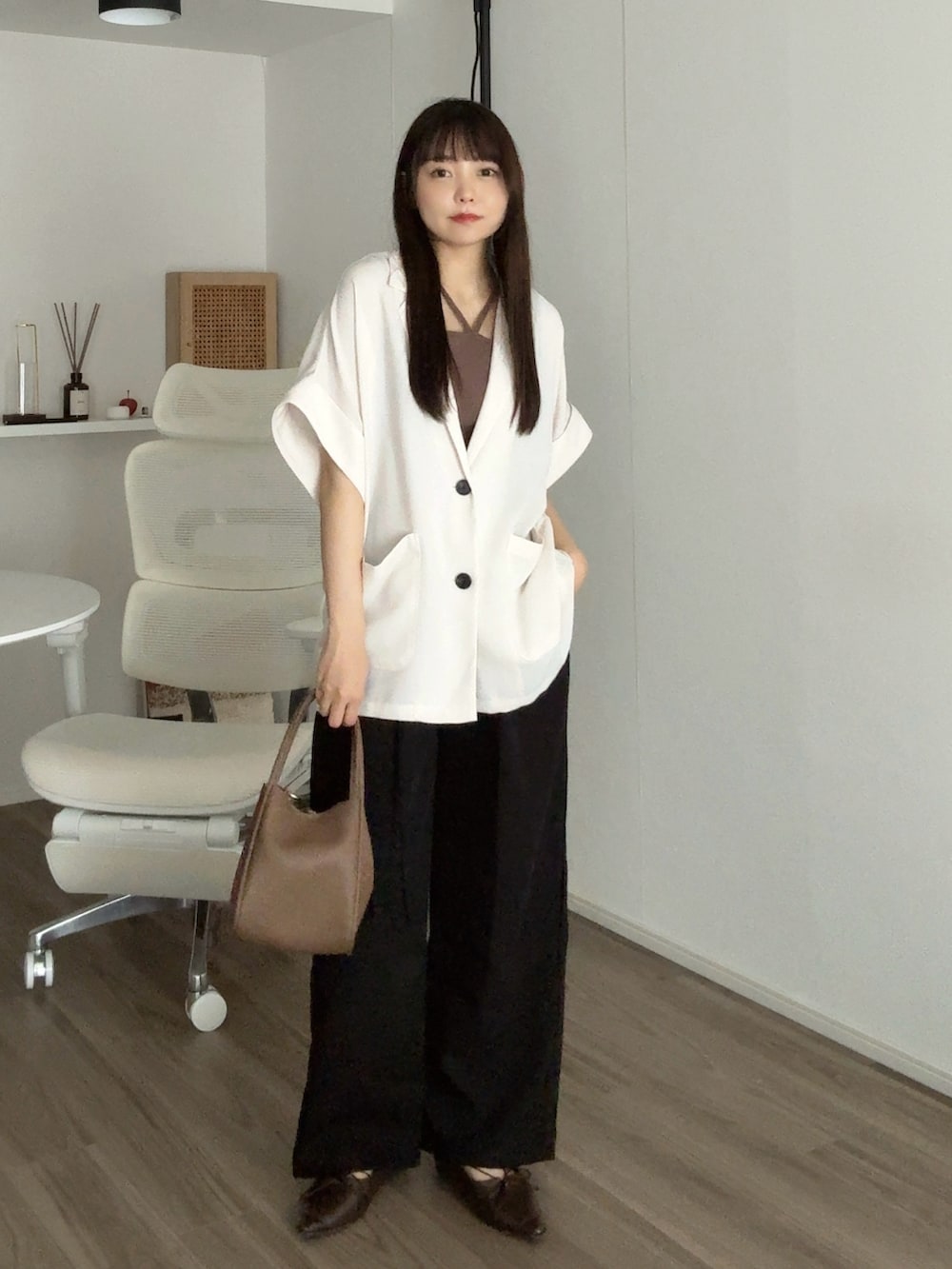 ホワイト系のテーラードジャケット、ブラック系のその他パンツ、ブラウン系のパンプスを着用したレディースの秋コーディネートの2枚目の写真