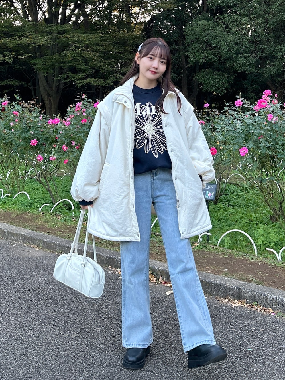 ホワイト系のダウンジャケット/コート、ブルー系のスウェット、ホワイト系のバッグを着用したレディースの冬コーディネートの2枚目の写真