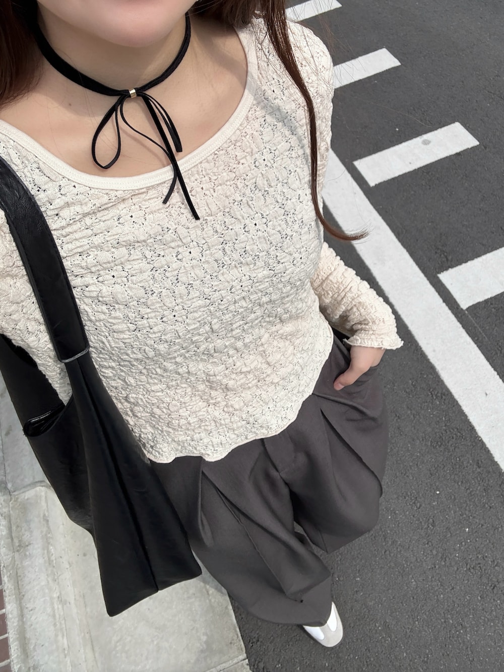 ブラック系のバッグ、ホワイト系のTシャツ/カットソー、グレー系のスラックスを着用したレディースの春コーディネートの3枚目の写真