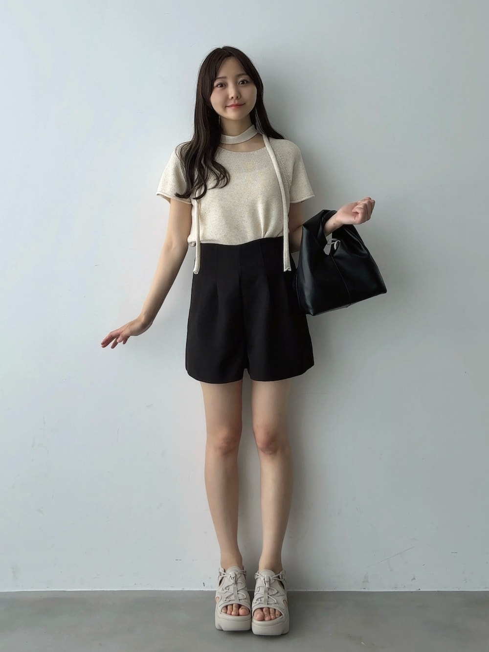 ベージュ系のTシャツ/カットソー、ブラック系のハンドバッグ、ブラック系のその他パンツを着用したレディースの夏コーディネートの2枚目の写真