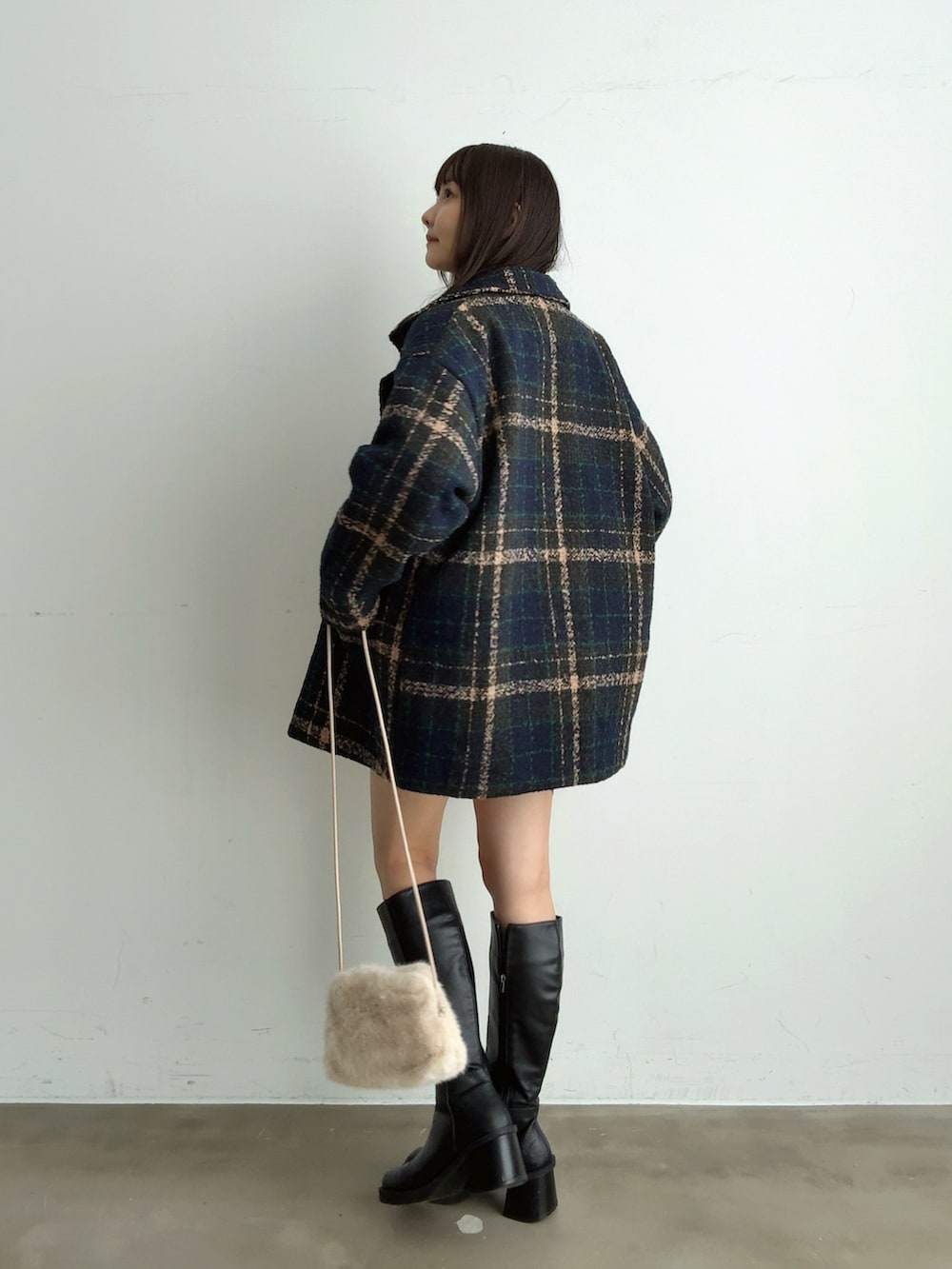 グレー系のニット/セーター、ホワイト系のスカート、ホワイト系のショルダーバッグを着用したレディースの冬コーディネートの2枚目の写真