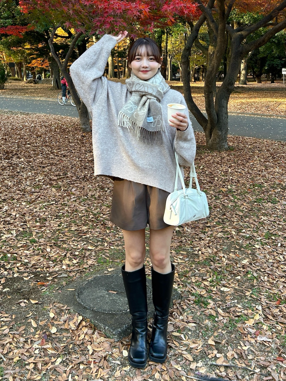 ホワイト系のバッグ、ブラック系のブーツ、ブラウン系のその他パンツを着用したレディースの冬コーディネートの4枚目の写真