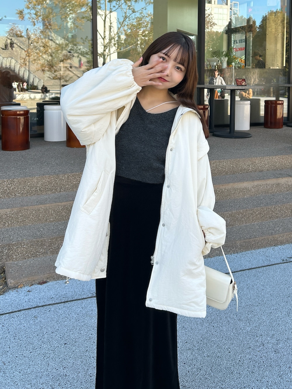 ホワイト系のキャミソール、グレー系のニット/セーター、ホワイト系のダウンジャケット/コートを着用したレディースの冬コーディネートの3枚目の写真