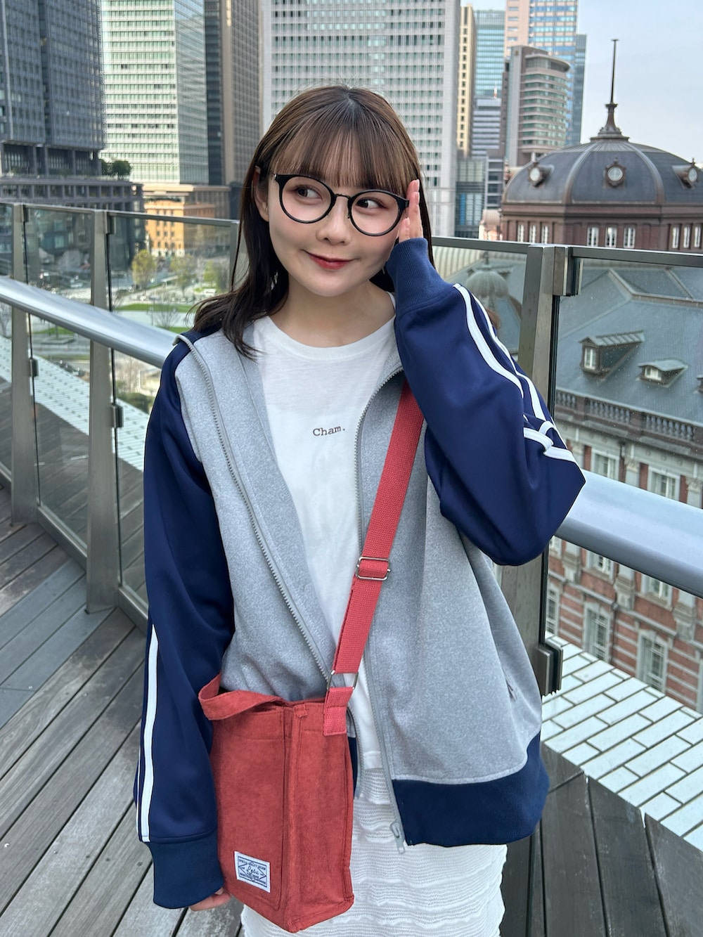 グレー系のブルゾン、ホワイト系のTシャツ/カットソー、レッド系のショルダーバッグを着用したレディースの春コーディネートの3枚目の写真