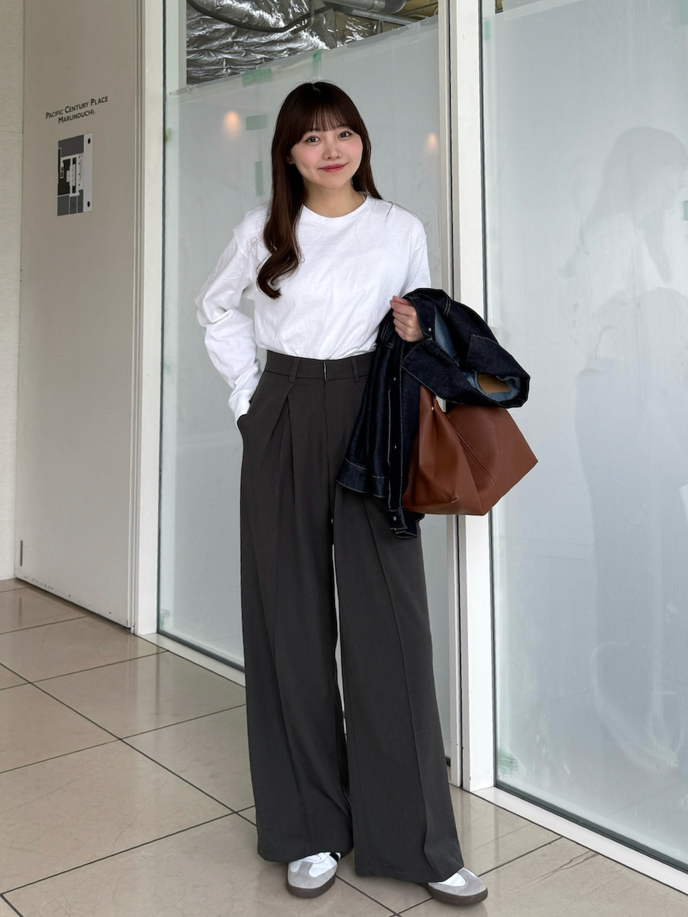 ホワイト系のTシャツ/カットソー、ブラック系のスラックス、ホワイト系のスニーカーを着用したレディースの春コーディネートの2枚目の写真