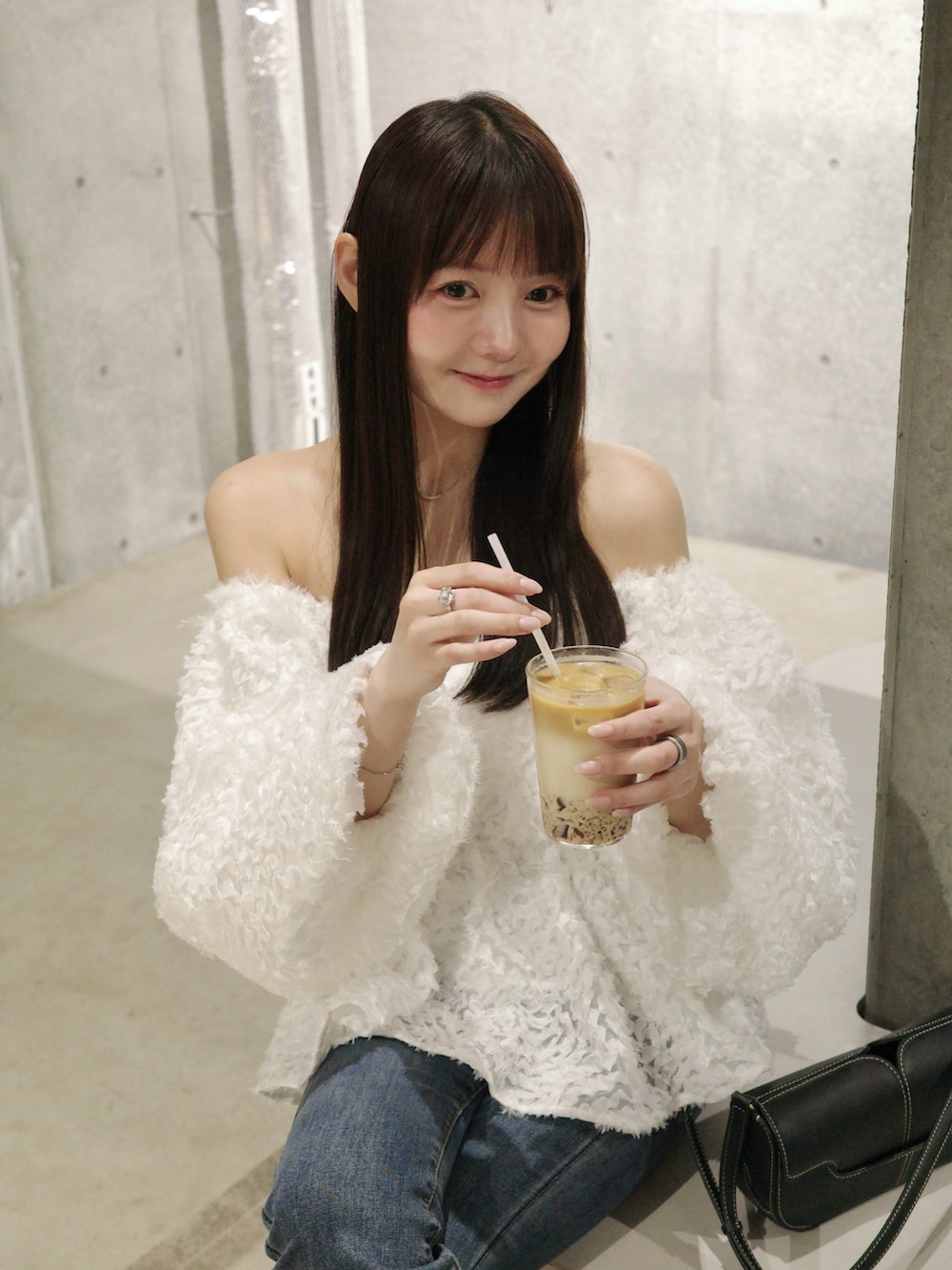 ブルー系のデニムパンツ、ベージュ系のサンダル、ホワイト系のトップスを着用したレディースの夏コーディネートの3枚目の写真