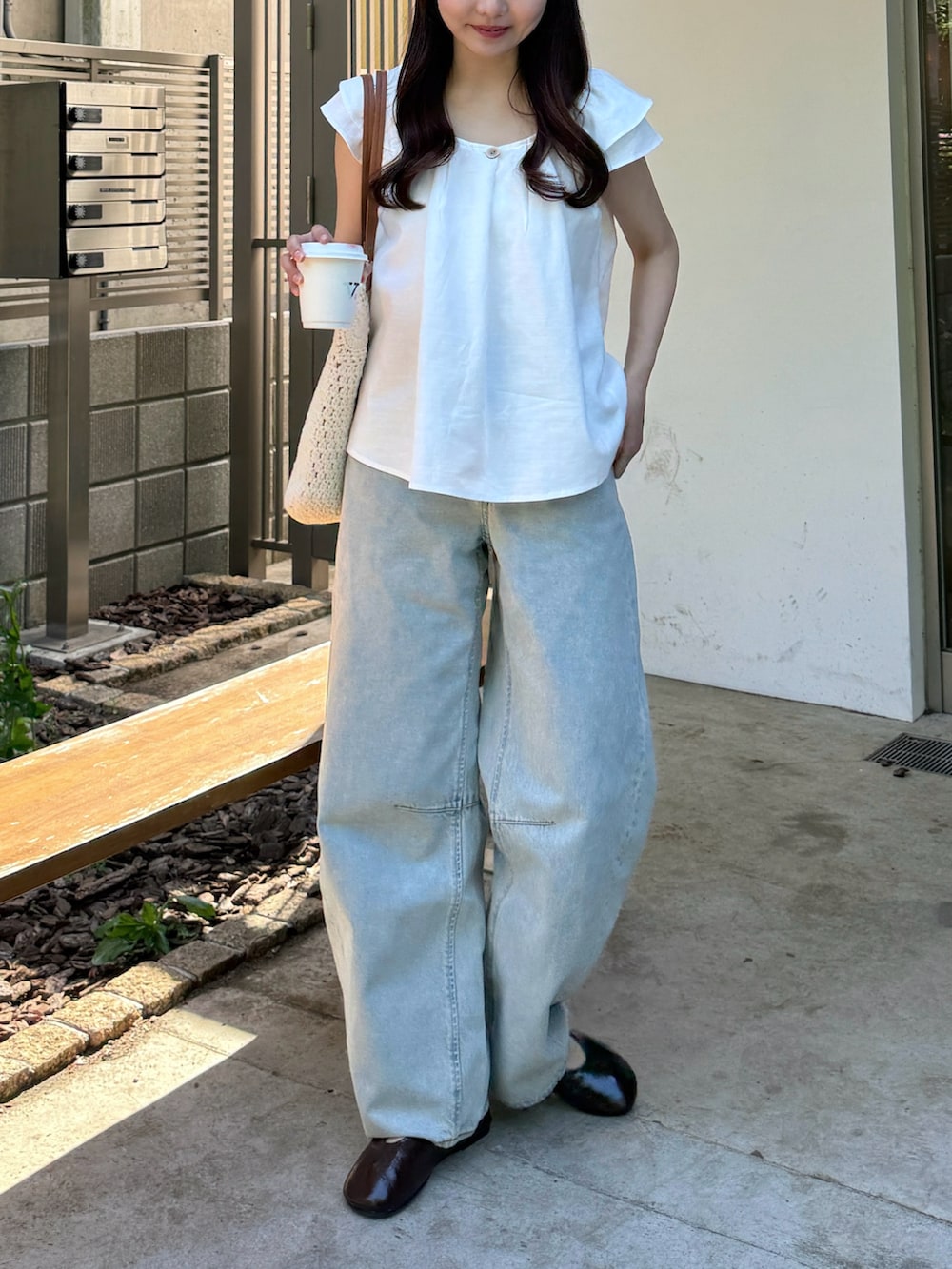 ホワイト系のシャツ/ブラウス、ホワイト系のトートバッグ、ブラウン系のパンプスを着用したレディースの夏コーディネートの3枚目の写真