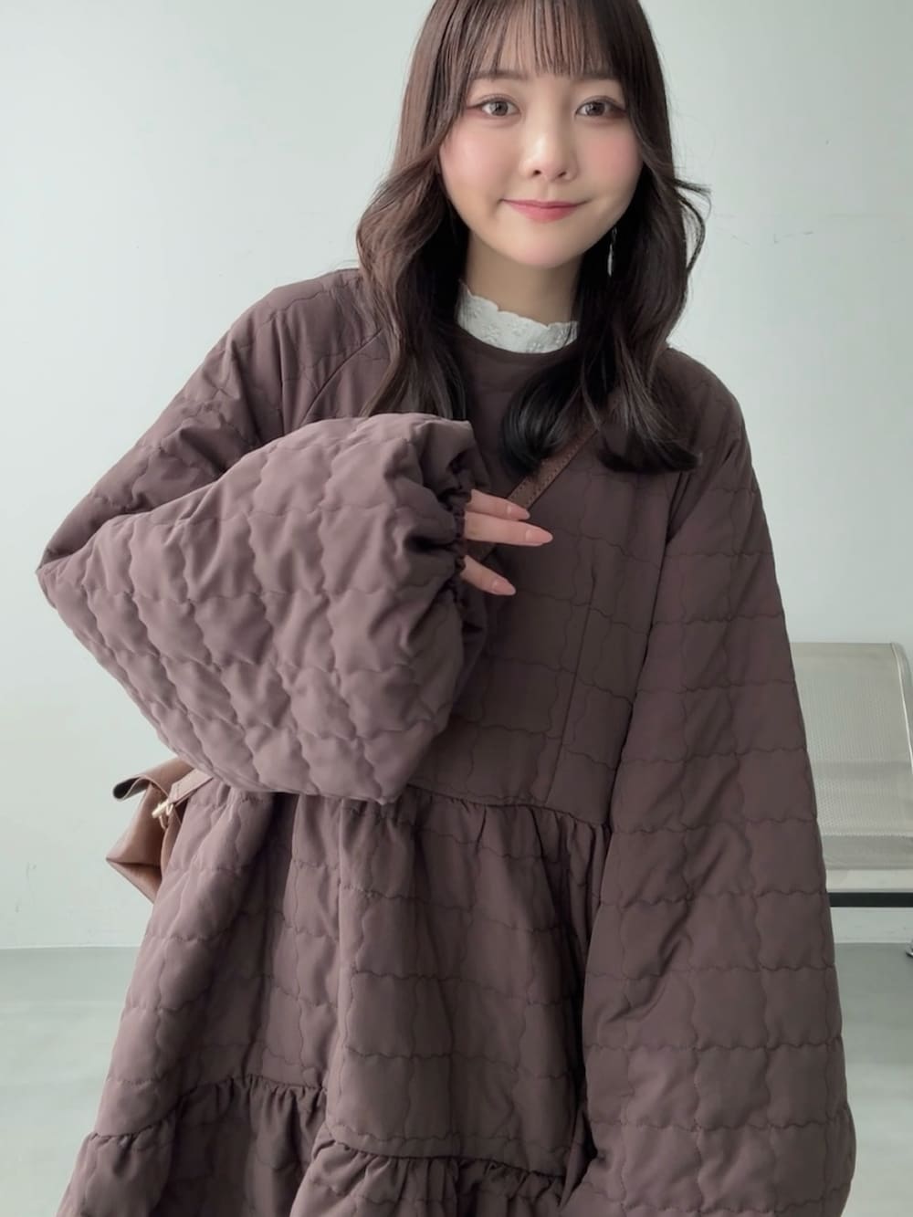 ホワイト系のスニーカー、ブラウン系のその他アウター、イエロー系のショルダーバッグを着用したレディースの冬コーディネートの4枚目の写真