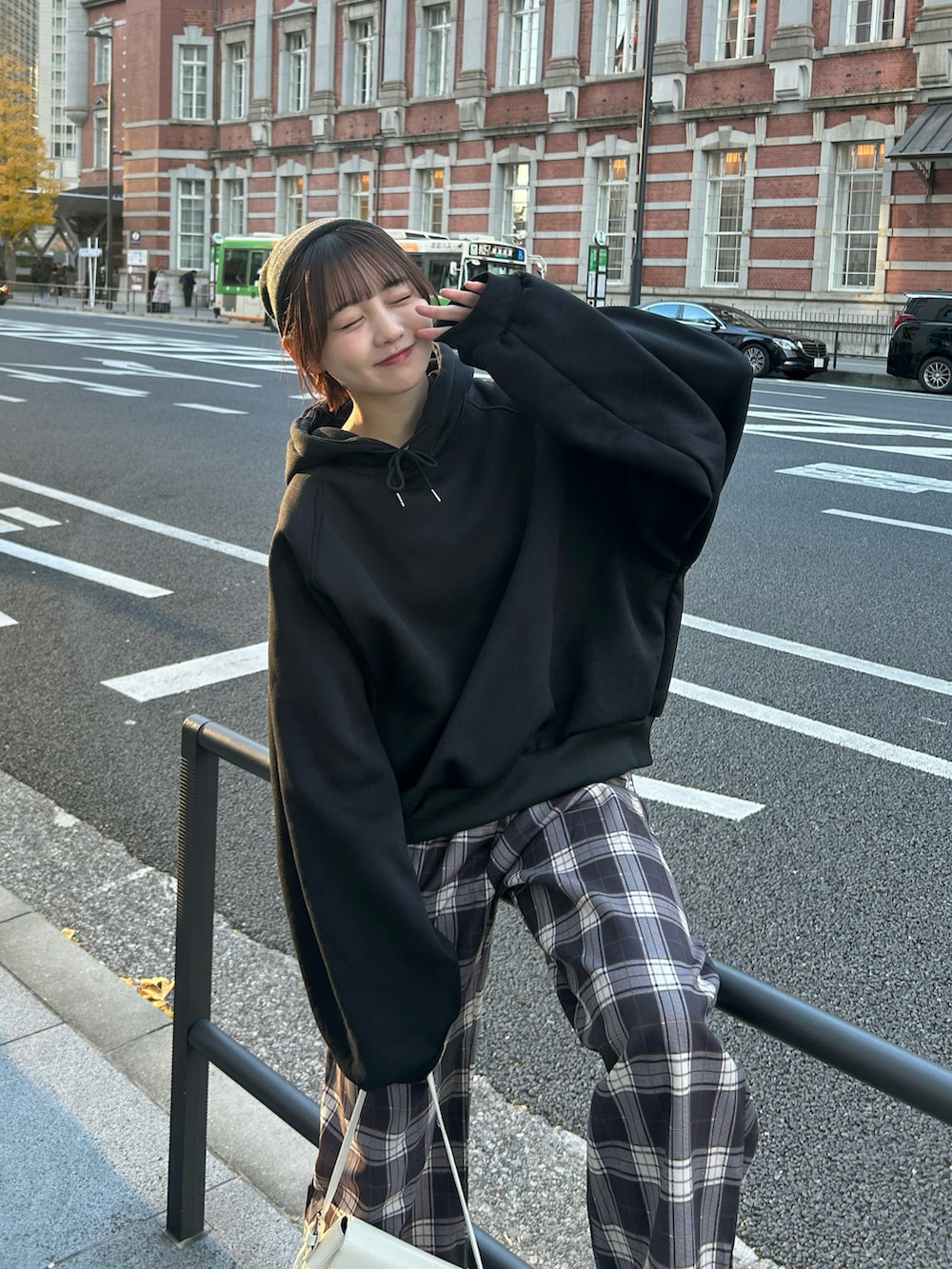 ブラック系のパーカー、ホワイト系のハンドバッグ、ブラウン系のその他パンツを着用したレディースの冬コーディネートの3枚目の写真