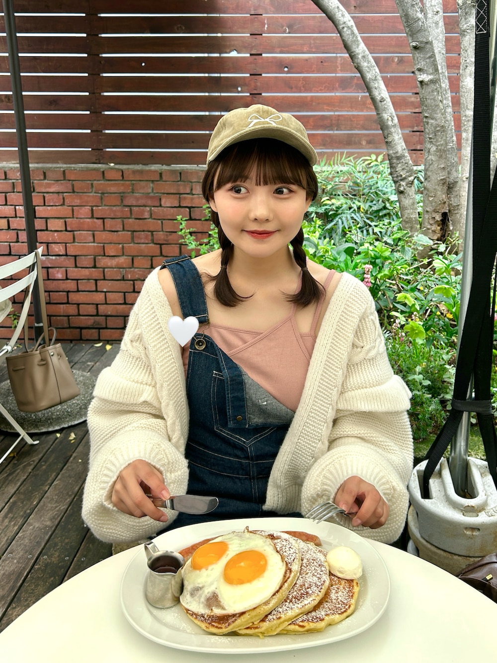 ピンク系のキャミソール、ブルー系のサロペット/オーバーオール、ホワイト系のスニーカーを着用したレディースの春コーディネートの3枚目の写真