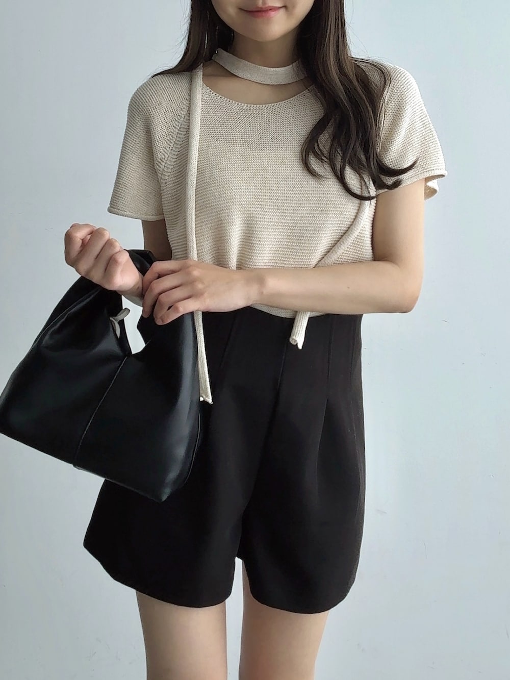 ベージュ系のTシャツ/カットソー、ブラック系のハンドバッグ、ブラック系のその他パンツを着用したレディースの夏コーディネートの4枚目の写真