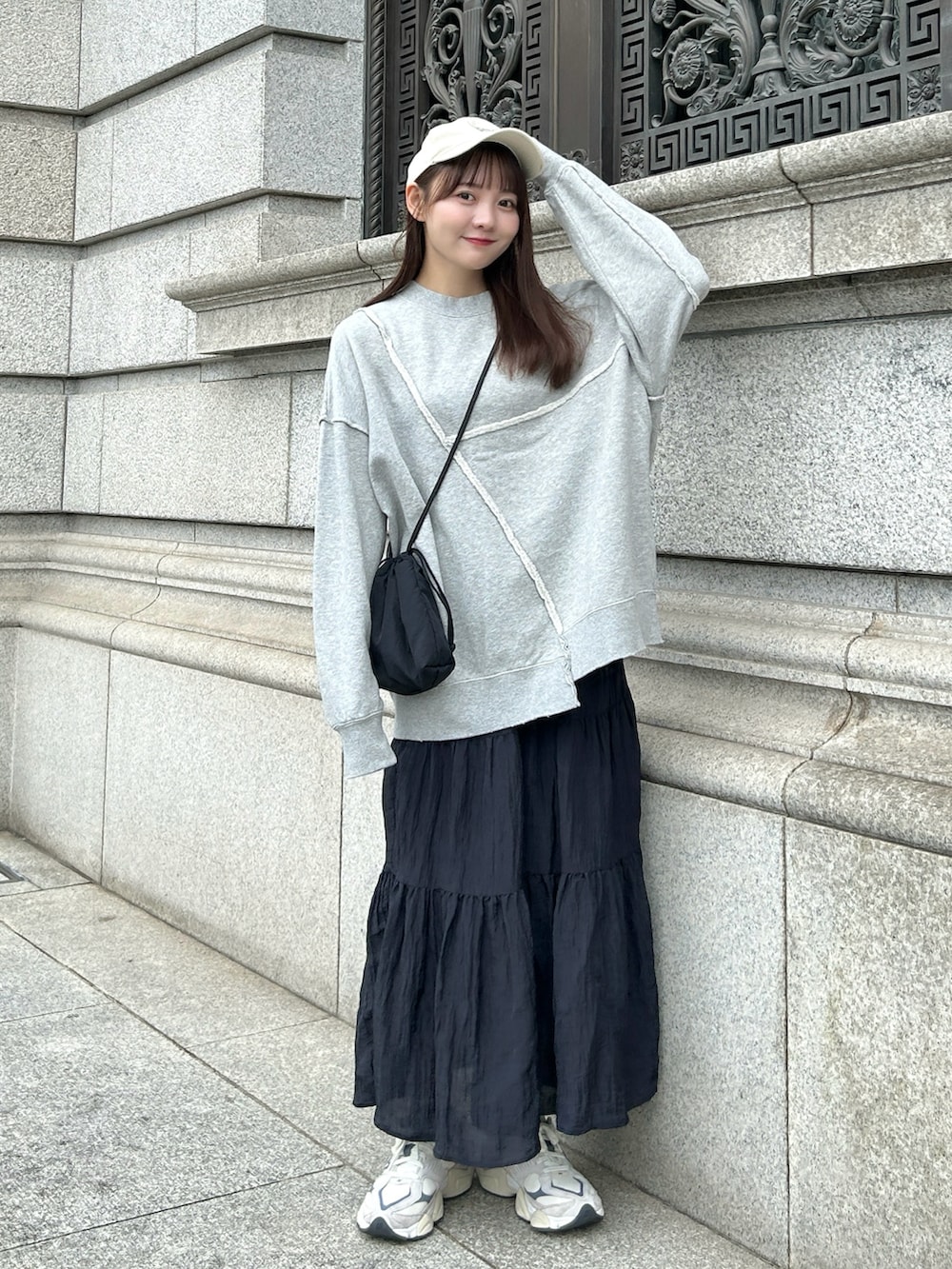 グレー系のスウェット、ブラック系のバッグ、ブラック系のスカートを着用したレディースの秋コーディネートの4枚目の写真