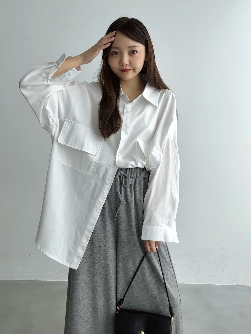 ホワイト系のシャツ/ブラウス、ブラウン系のショルダーバッグ、ホワイト系のパンプスを着用したレディースの秋コーディネートの2枚目の写真