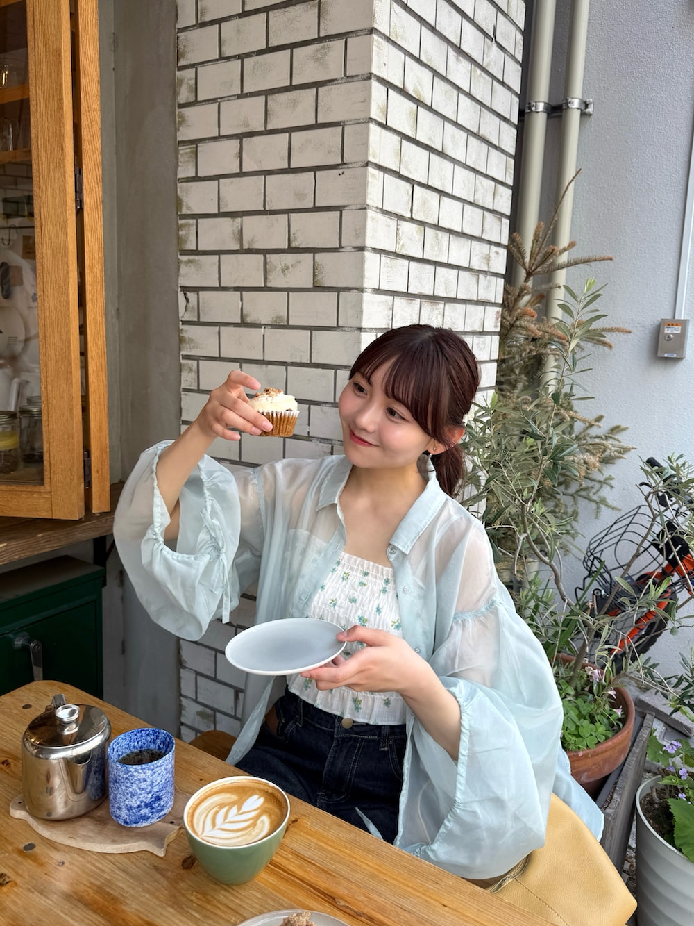 グリーン系のキャミソール、グリーン系のシャツ/ブラウス、イエロー系のハンドバッグを着用したレディースの春コーディネートの3枚目の写真