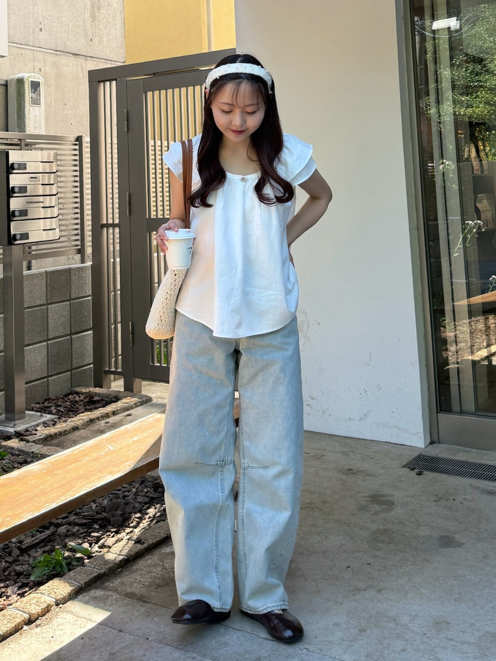 ホワイト系のシャツ/ブラウス、ホワイト系のトートバッグ、ブラウン系のパンプスを着用したレディースの夏コーディネートの2枚目の写真