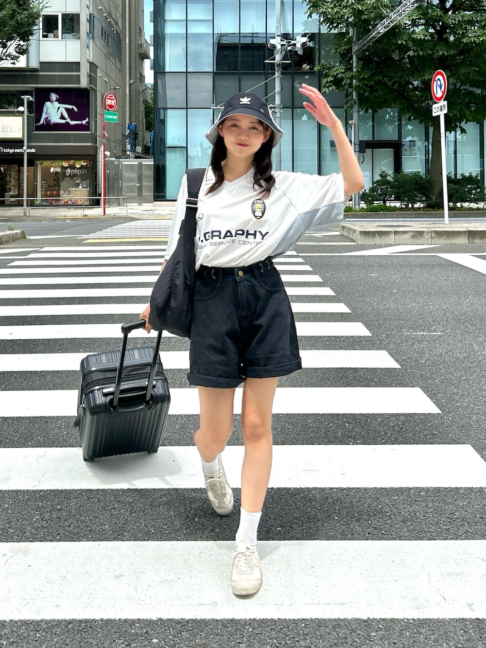 ブラック系のショルダーバッグ、ホワイト系のTシャツ/カットソー、ブラック系のデニムパンツを着用したレディースの夏コーディネートの5枚目の写真