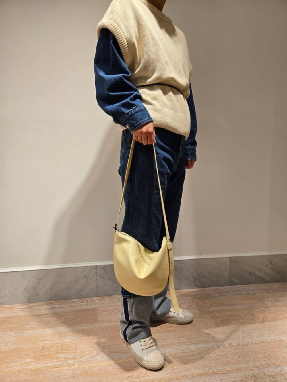 ブルー系のデニムパンツ、ホワイト系のニット/セーター、ブルー系のデニムジャケットを着用したレディースの秋コーディネートの2枚目の写真