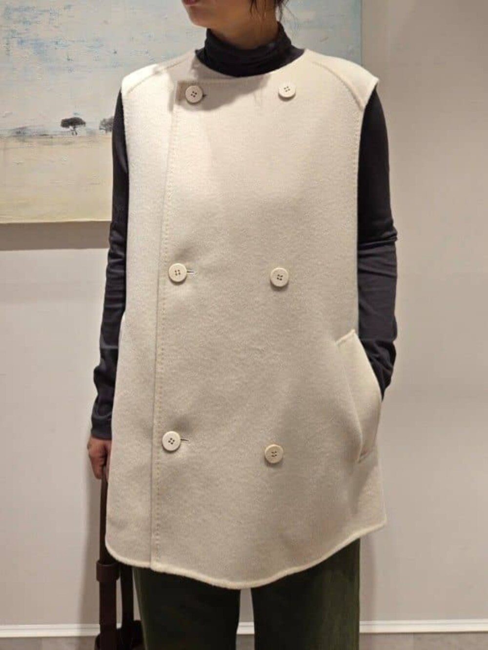 ホワイト系のベスト、グレー系のTシャツ/カットソー、ブラウン系のショルダーバッグを着用したレディースの秋コーディネートの4枚目の写真