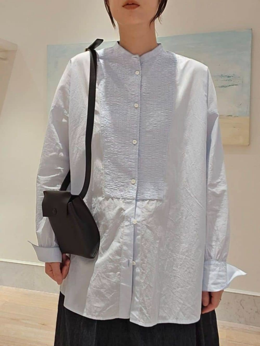 ブルー系のシャツ/ブラウス、ブルー系のデニムスカート、ブラウン系のブーツを着用したレディースの秋コーディネートの3枚目の写真