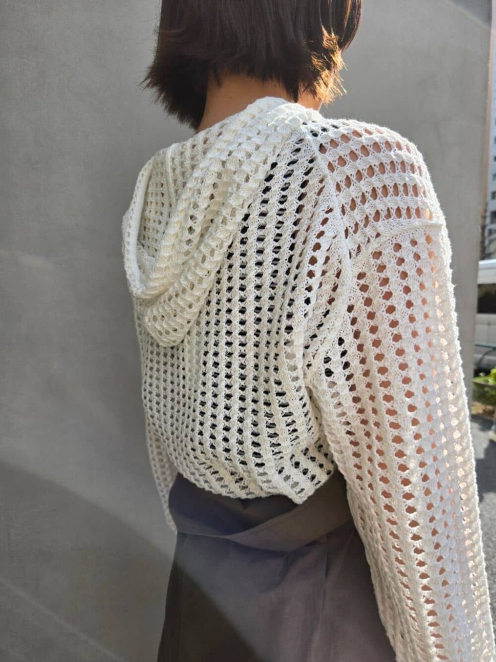 ホワイト系のパーカー、グリーン系のその他パンツ、ブラウン系のハンドバッグを着用したレディースの春コーディネートの5枚目の写真