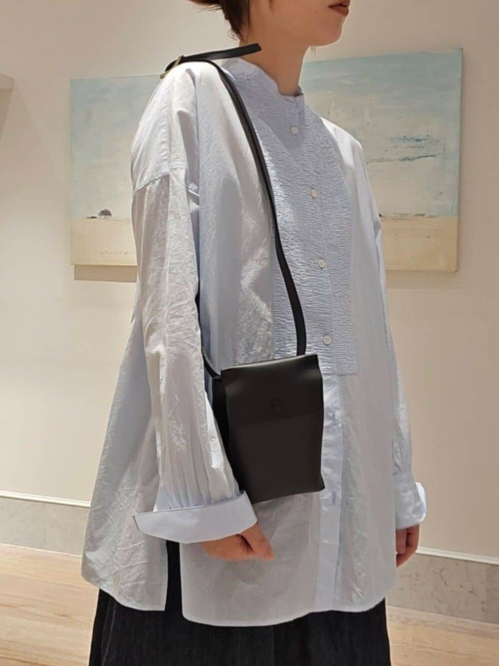 ブルー系のシャツ/ブラウス、ブルー系のデニムスカート、ブラウン系のブーツを着用したレディースの秋コーディネートの2枚目の写真