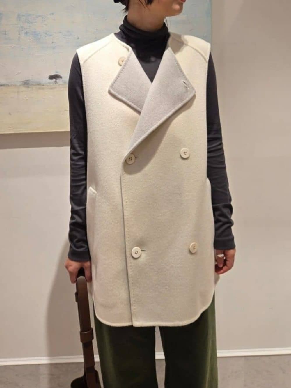 ホワイト系のベスト、グレー系のTシャツ/カットソー、ブラウン系のショルダーバッグを着用したレディースの秋コーディネートの3枚目の写真