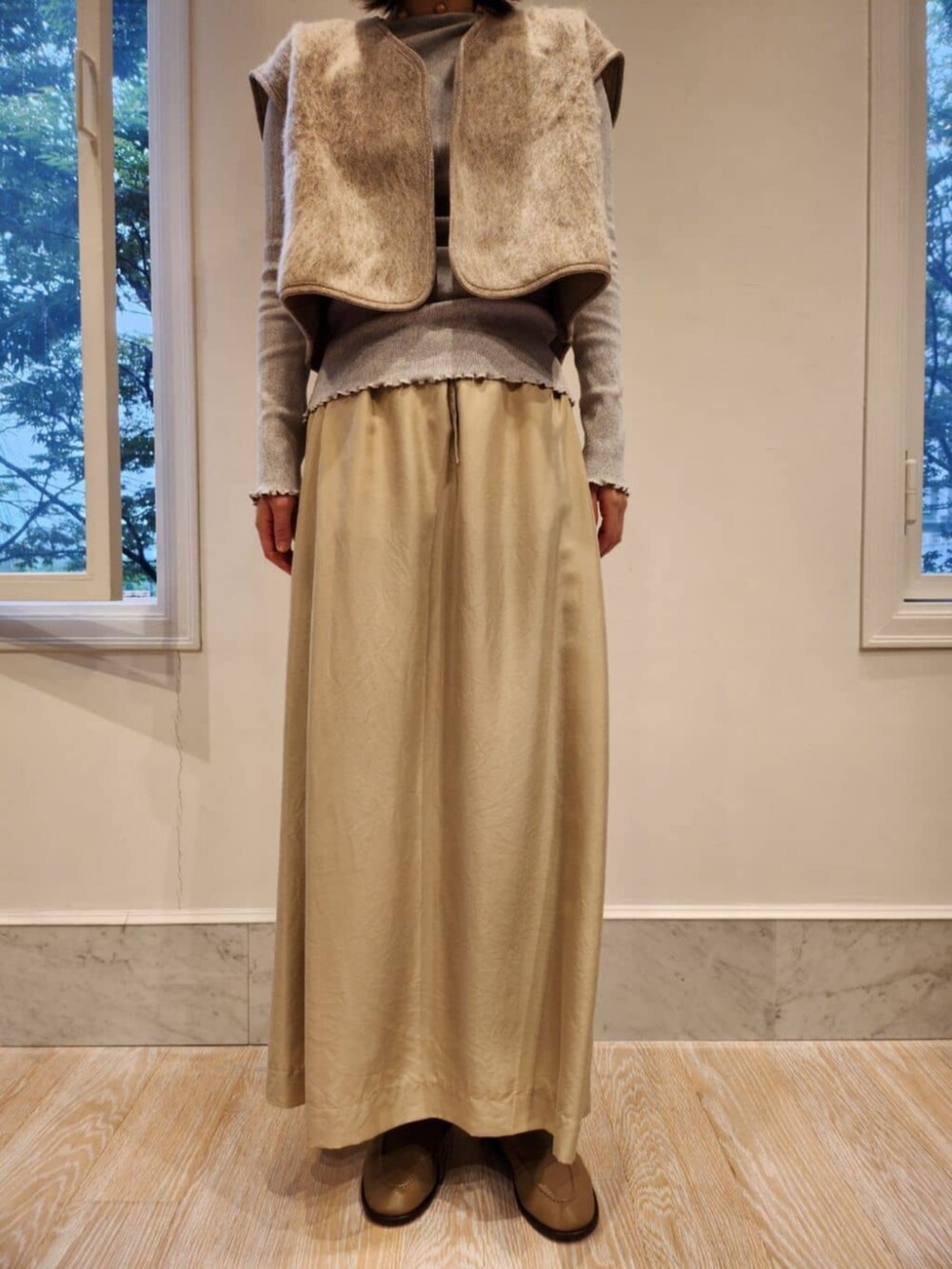 グレー系のブーツ、ベージュ系のベスト、グレー系のTシャツ/カットソーを着用したレディースの秋コーディネートの5枚目の写真